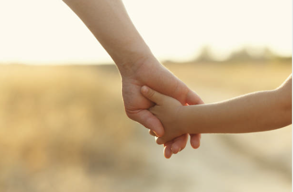 photo d'une main d'adulte dans une main d'enfant, montrant l'union d'un pere ou d'une mere avec son enfant