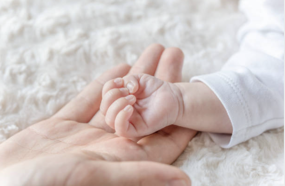 photo d'une main de bébé dans la main de sa mere ou de son pere